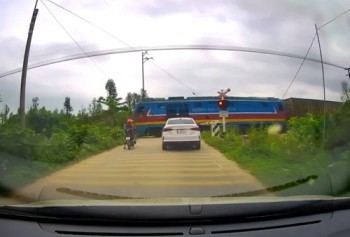 Thót tim cảnh 2 nữ sinh vượt rào chắn đường sắt trước đoàn tàu đang tới